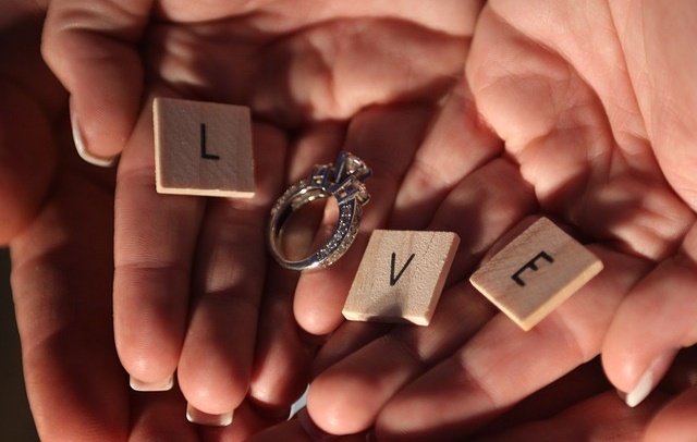 Dłonie z napisem miłość i obrączkami ślubnymi